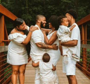 man in white dress shirt carrying baby in white dress